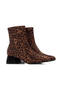 Botas tobilleras con estampado de leopardo, en acabados de ante marrón y negro, puntera afilada y tacón en bloque. La base del tacón es negra y transparente.