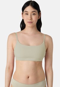 Světle zelený bralet s tenkými nastavovacími ramínky, hladkým povrchem a čtvercovým výstřihem, navržený pro pohodlí a jednoduchost.