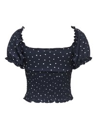Blouse courte bleu marine à pois blancs, manches courtes bouffantes, taille smockée et ourlet à volants.