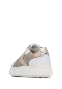 Sneaker chunky con una combinazione di colori bianco e oro metallico. Presenta materiali lisci e testurizzati, una fascia in velcro e suola a rilievo.