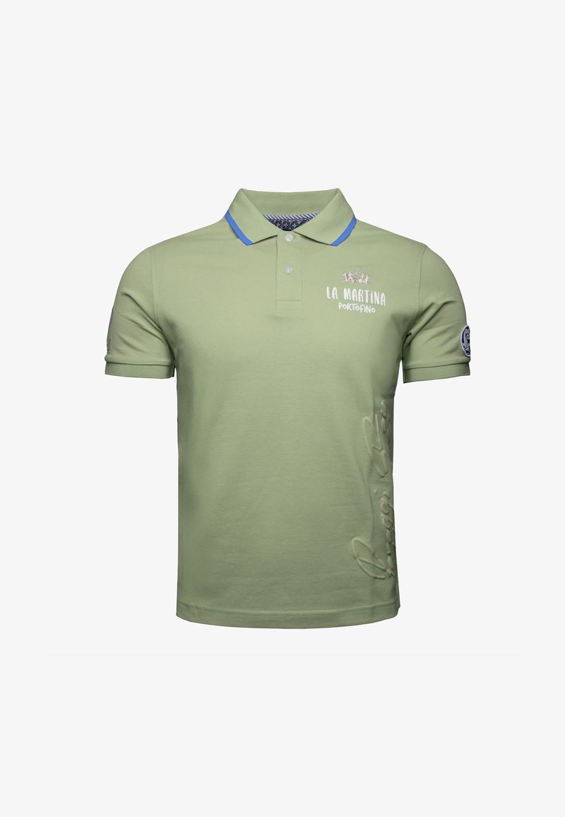 Vihreä polo-paita, jossa on sininen kaulus, ja rintapuolella brodeerattu logoteksti sekä hienovarainen kirjoitussisältö kyljessä.