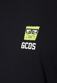 Černé tričko s vyšívaným designem Spongeboba SquarePanta, který má brýle, a textem "GCDS" bíle pod grafikou.