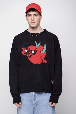 Zwarte gebreide trui met een rode cartoon-tomaat met zonnebril en een groene worm. Gekocht met lichtblauwe jeans en een rode pet.