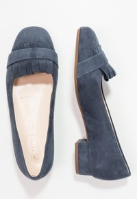 Scarpe in suede blu navy con tacco a blocco e punta arrotondata, dotate di una cinghia decorativa frangiata sul davanti. Fodera interna liscia.