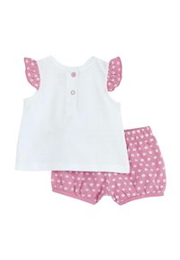 Top senza maniche bianco con maniche arricciate rosa e bottoni sul retro, abbinato a pantaloni corti rosa con motivi a pois bianchi.