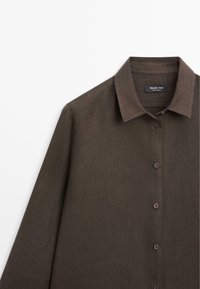 Donkerbruin overhemd met lange mouwen, knoopsluiting en klassieke kraag, met een zichtbaar label binnenin de kraag met de tekst "Massimo Dutti".