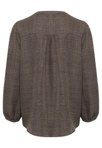 Blusa marrón de manga larga con una tela texturizada, ligeramente fruncida en la parte de atrás y un escote redondeado. Presenta puños elásticos y un corte relajado.