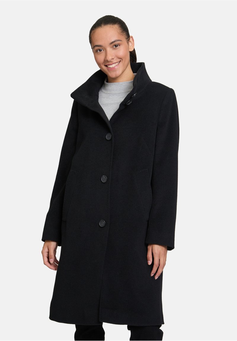Cappotto in misto lana nero con colletto alto, dotato di chiusura a bottoni, due tasche laterali e silhouette dritta.