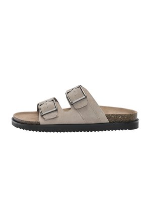 Sandali in suede grigio chiaro con due fibbie regolabili in argento, suola intermedia in sughero e suola esterna in gomma nera con scanalature per la trazione.