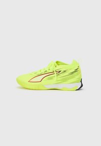 Scarpa atletica giallo neon con superficie strutturata, dettagli rossi, suola ammortizzata e design leggero con lacci.