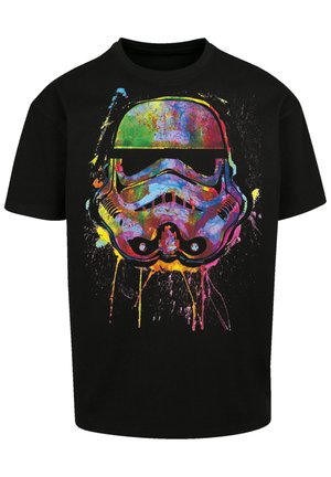 Svart bomull t-skjorte med et fargerikt grafisk trykk av et stormtrooper-hjelm med malingsøl i rosa, gult og blåtoner.