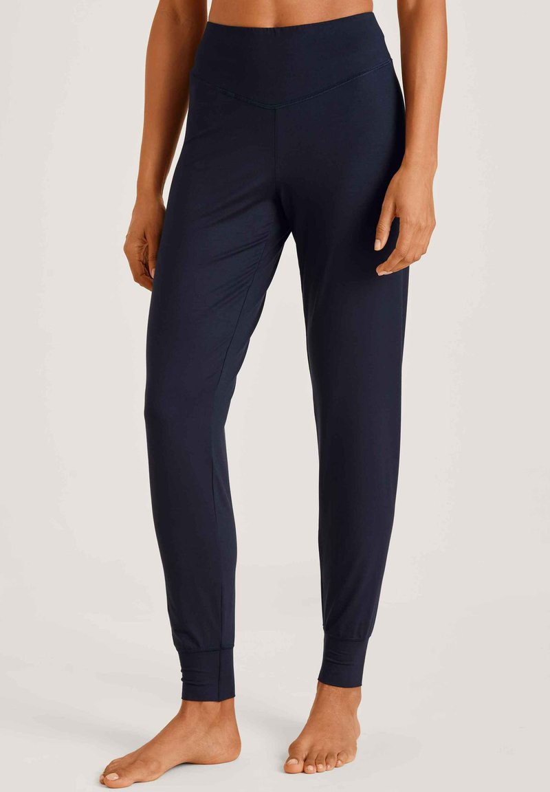 Marine fitnessbroek gemaakt van rekbaar stof met een hoge tailleband, taps toelopende pijpen en aansluitende boorden bij de enkels.