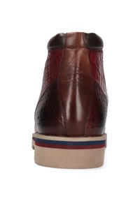 Brązowy skórzany sneaker z wysoką cholewką, teksturowanymi panelami, czerwonymi akcentami i kremową gumową podeszwą z paskowym wzorem.