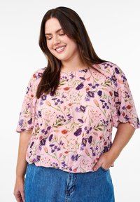 Blusa a maniche corte in tessuto rosa chiaro con stampa floreale che presenta fiori viola e rossi, scollatura rotonda e vestibilità comoda.