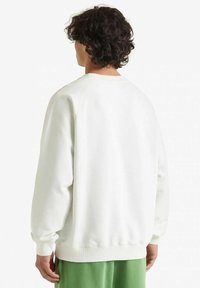 Felpa bianca in pile con polsini e orlo a costine, caratterizzata da un classico design a girocollo e maniche raglan, mostrata di spalle.