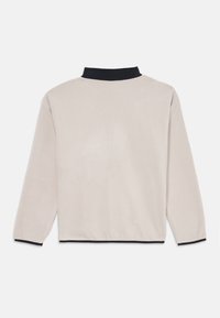 Pull léger couleur beige clair avec des manches longues, doté d'un col noir et de poignets noirs. Texture douce, design minimal sans motifs supplémentaires.