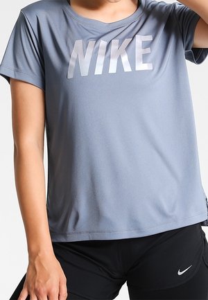 Grå sports T-shirt lavet af åndbart stof med et stort hvidt "NIKE" logo på brystet. Korte ærmer og løs pasform.