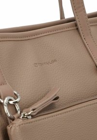 Beige leren handtas met een gestructureerd oppervlak, twee hengsels, een ritsvak en een op de voorkant gegraveerd merkteken.