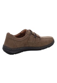 Brown suede shoe with a low profile, contrasting stitching, elastic straps, and a textured black rubber sole.