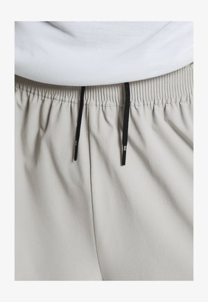 Hellgraue Shorts mit elastischem Bund und schwarzen Kordeln, die eine glatte, weiche Textur und ein dezentes, gerafftes Stoffdesign aufweisen.