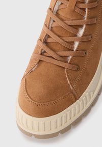Baskets en daim marron avec des superpositions texturées, des lacets ronds et une semelle en caoutchouc couleur crème avec des accents rainurés.