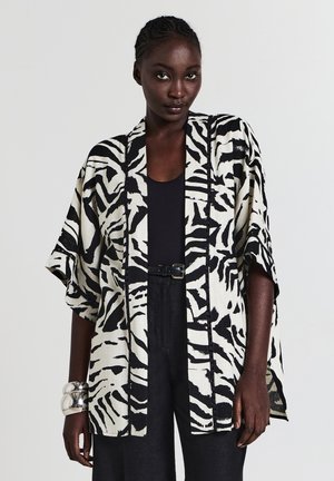 Schwarze und weiße Zebramuster-Kimono-Jacke mit lockeren Ärmeln, leichtem Stoff, offener Front und kontrastierendem schwarzen Besatz.