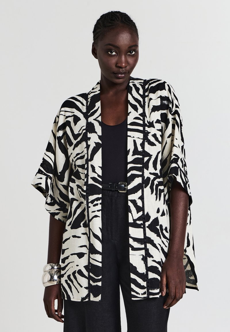 Schwarze und weiße Zebramuster-Kimono-Jacke mit lockeren Ärmeln, leichtem Stoff, offener Front und kontrastierendem schwarzen Besatz.