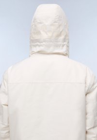 Witte waterdichte jas met capuchon, voorzien van een gegarneerde bovenrug. Soepele, matte textuur; ontworpen voor buitengebruik.