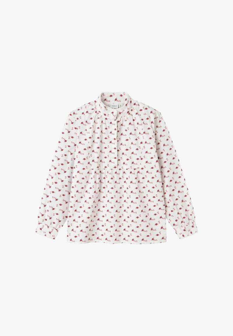 Maglietta bianca a maniche lunghe con colletto tondo, caratterizzata da un motivo floreale di fiori rossi, pieghe sullo scollo e chiusura con bottoni.