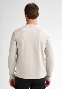 Camisa de manga larga en gris claro con rayas horizontales. Cuello redondo, textura suave y un corte relajado. Presenta una etiqueta en el lateral.
