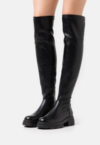 Czarne skórzane kozaki za kolano o eleganckim designie, z bocznym zamkiem błyskawicznym i masywną gumową podeszwą. Gładka faktura z minimalnymi detalami przeszyć.