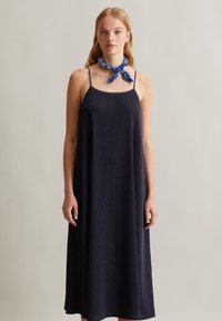 Navyblaues, geripptes Maxikleid mit verstellbaren Spaghettiträgern. Bietet eine lockere Passform und einen strukturierten Stoff. Ergänzt durch einen blauen, gemusterten Schal.