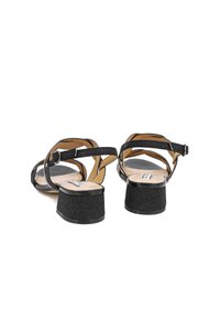 Sandali neri con cinturini, rifiniti con una texture glitterata, dotati di tacco basso e chiusura con cinturino alla caviglia. Rivestimento interno liscio.