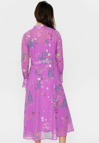 Rochie midi floral�ă mov cu mâneci lungi, material transparent, talie accentuată cu un cordon și detalii decorative în verde și alb.
