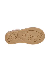 Suela de un zapato beige con patrones de tracción circulares y ovalados, con la talla marcada como 25, presentada sobre un fondo blanco.
