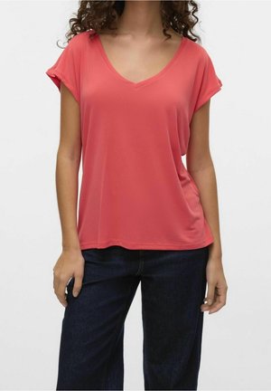 T-shirt a V con maniche corte arrotolate color corallo, in tessuto morbido, vestibilità comoda, abbinato a jeans a gamba larga blu scuro.