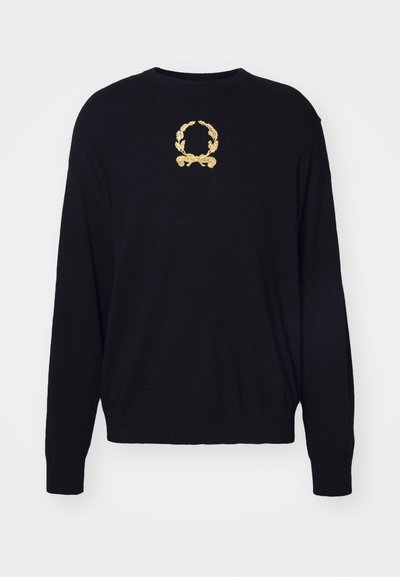 Čierny sveter vyrobený z mäkkej tkaniny, s vyšívaným zlatým designom vavrínového veniec na hrudi a rebrovanými manžetami a spodným lemom.