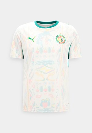Tricou de fotbal alb cu mâneci scurte și guler verde, logo Puma pe pieptul drept și emblema echipei naționale a Senegalului pe pieptul stâng.