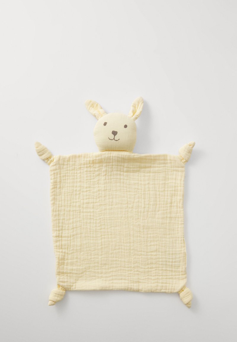 Mehka rumena muslin odeja s zajčkom oblikovano glavo, ki ima izšite obrazne detajle in štiri zavezane vogale za teksturo.