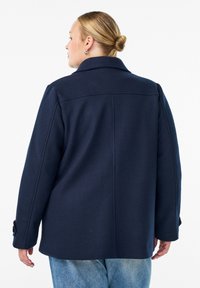 Námořnický kabát z vlněné směsi s klopovým límcem, dlouhými rukávy a knoflíkovými detaily na manžetách, s rovnýcm střihem a zadními švy.