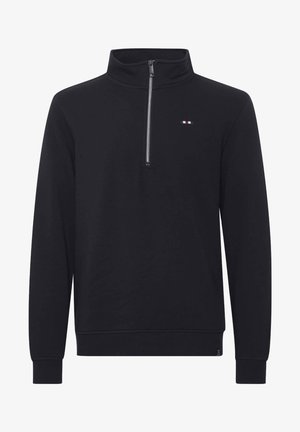 Fekete, negyed cipzáros pulóver puha anyagból. Magas gallérral, hosszú ujjakkal rendelkezik, és egy kis logóval, piros, fehér és kék részletekkel.