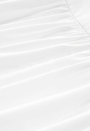 Balta medžiaga su švelniu drapiruote ir raukšlių tekstūra, pasižyminti lygiu, lengvu audiniu švarioje, aštrioje prezentacijoje.