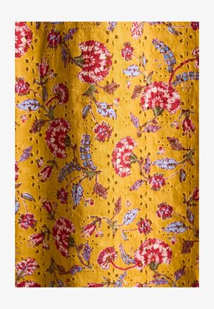 Gelbes Gewebe mit floralem Muster, das rote und blaue Blumen zeigt, verziert mit kleinen Lochungen im gesamten Material.