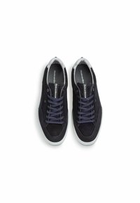 Navy Suede Sneakers mit grauen Akzenten, runder Zehenpartie und Stoffbändern. Die Gummisohle verfügt über einen strukturierten Grip. Der Markenname ist auf der Innensohle sichtbar.