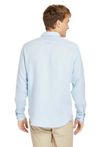 Camicia azzurro chiaro a maniche lunghe con bottoni, realizzata in un tessuto leggero, dotata di orlo curvo e polsini con bottoni semplici.