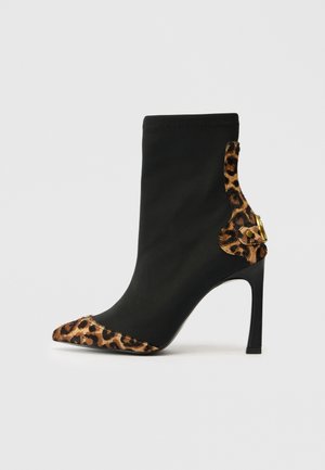 Stivale nero alla caviglia con punta appuntita, caratterizzato da dettagli con stampa leopardata, tessuto testurizzato e alto tacco a stiletto con hardware dorato.