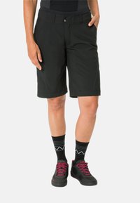 Pantalones cortos ligeros negros con una textura suave, que cuentan con un cierre de botón, bolsillos frontales en ángulo y detalles de costura en contraste.