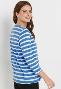 Blau-weißer gestreifter Langarm-T-Shirt, weicher Stoff, runder Ausschnitt, lässige Passform, leichte Seitenschlitze am Saum. Keine weiteren Details.