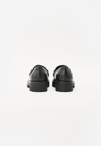 Black leather shoes featuring a rugged sole, rounded shape, and decorative hardware accents on the sides. Textured with visible stitching.
