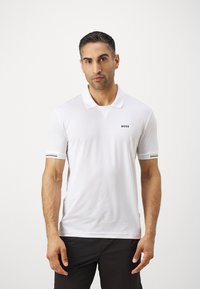 Λευκό πόλο μπλουζάκι με κοντά μανίκια, κολάρο και μικρό λογότυπο "BOSS". Διαθέτει μαύρες και χρυσές ρίγες στις μανσέτες.